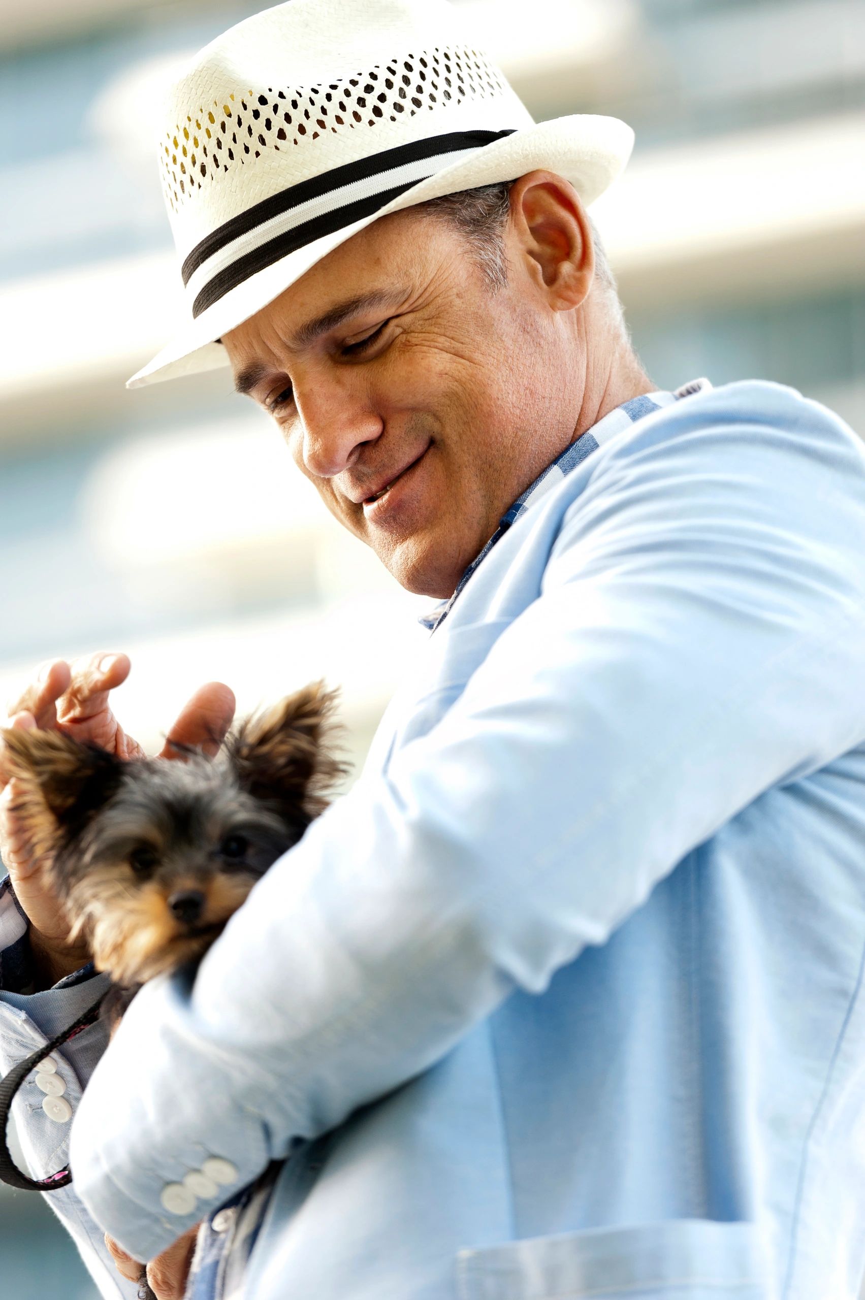 Hombre sosteniendo a su perro en la ciudad